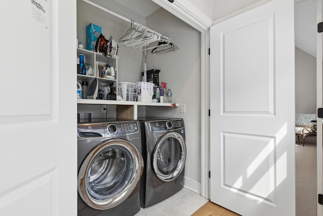 washroom with tile patterned floors, laundry area, and washer and dryer