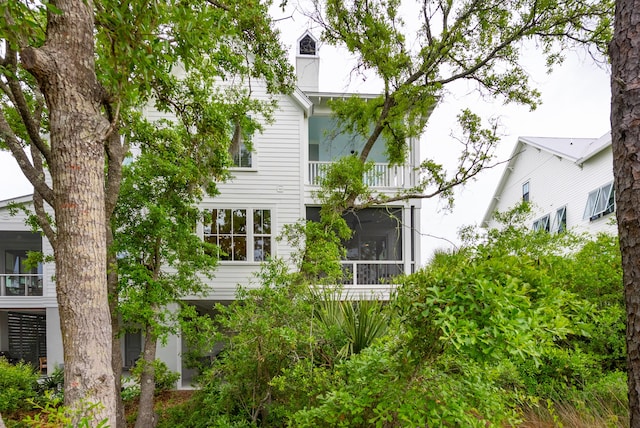 rear view of house with a sunroom and a balcony