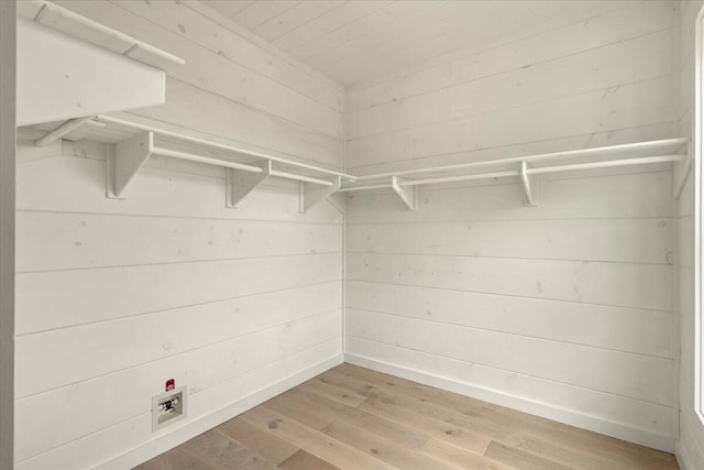 walk in closet with light hardwood / wood-style floors