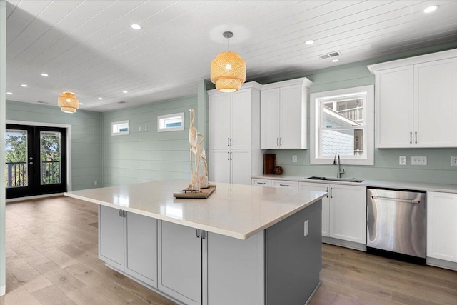 kitchen with white cabinetry, pendant lighting, sink, dishwasher, and a center island