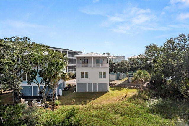 back of property with a yard and a balcony