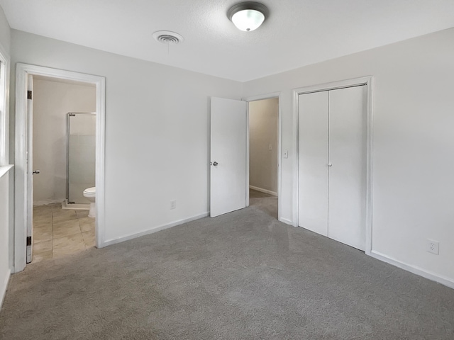 unfurnished bedroom with carpet flooring, connected bathroom, and a closet