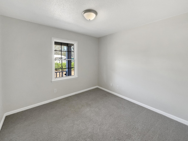 carpeted empty room with a textured ceiling