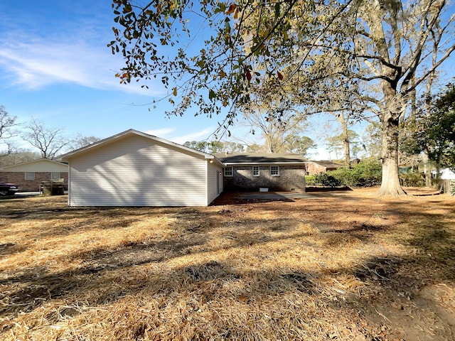 view of side of home with a lawn