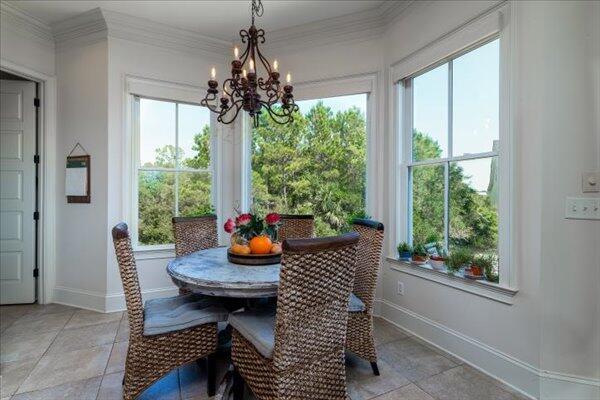 dining room with a chandelier, baseboards, and crown molding