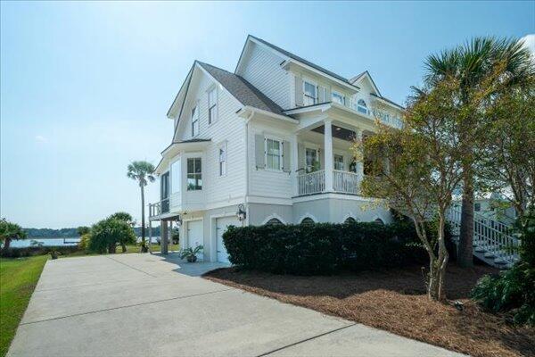 view of home's exterior with a garage, driveway, stairway, and a balcony