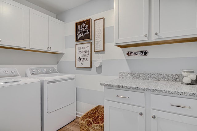 washroom featuring cabinets, independent washer and dryer, and light wood-type flooring