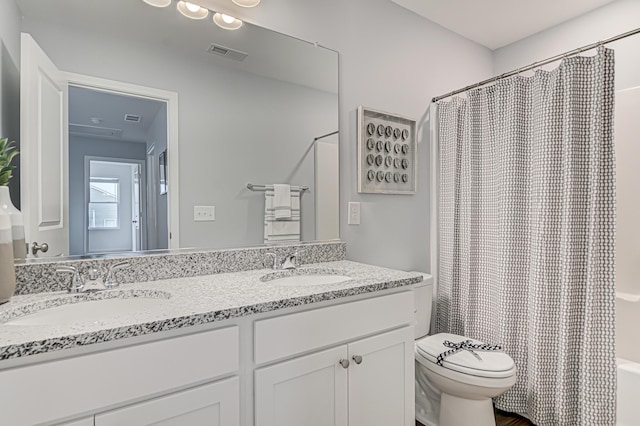 full bathroom with vanity, shower / tub combo, and toilet