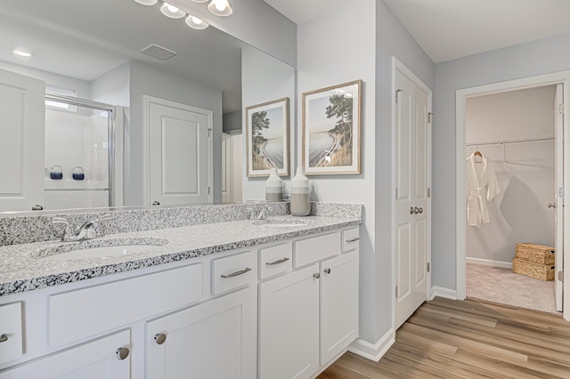 bathroom featuring hardwood / wood-style floors, vanity, and an enclosed shower