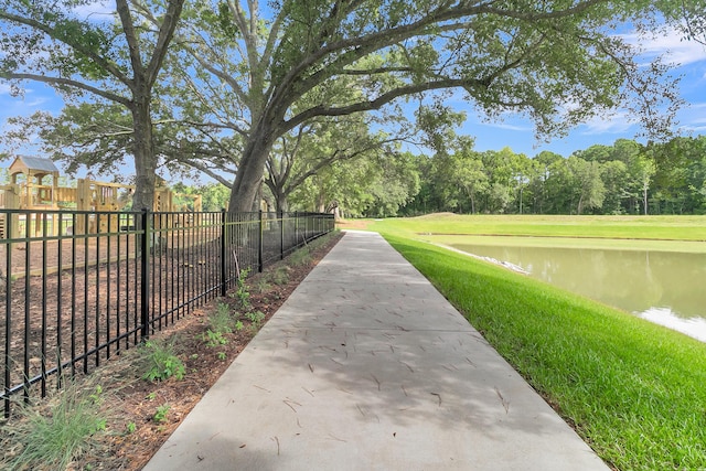 view of property's community with a water view and a yard