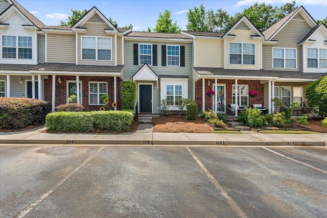 townhome / multi-family property featuring uncovered parking and brick siding