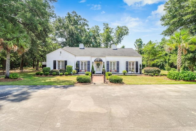 ranch-style home with stucco siding and a front lawn