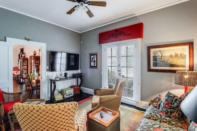 living room featuring baseboards, wood finished floors, ceiling fan, and crown molding