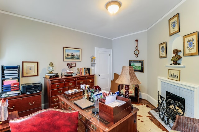office space with wood finished floors, baseboards, a fireplace, and crown molding