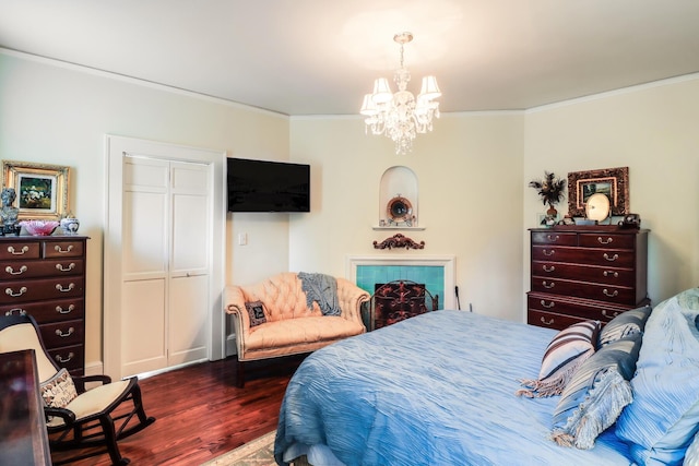 bedroom featuring a closet, an inviting chandelier, dark wood-type flooring, and ornamental molding
