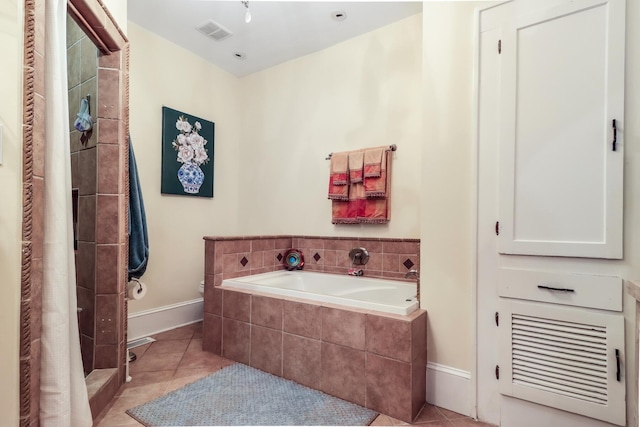 bathroom featuring tile patterned floors, visible vents, baseboards, a garden tub, and tiled shower