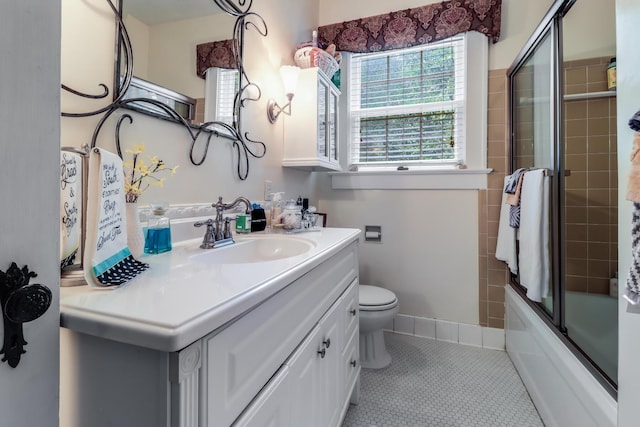 full bathroom featuring toilet, vanity, tile patterned floors, and combined bath / shower with glass door