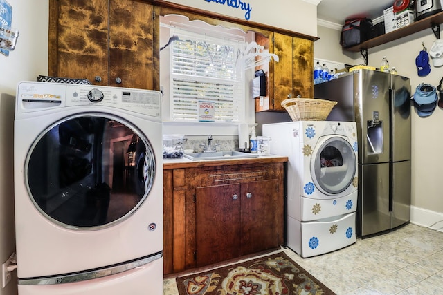 washroom with washer and clothes dryer, light tile patterned floors, a sink, cabinet space, and indoor wet bar