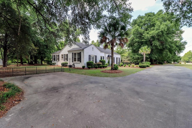 view of front of home featuring fence, driveway, and stucco siding
