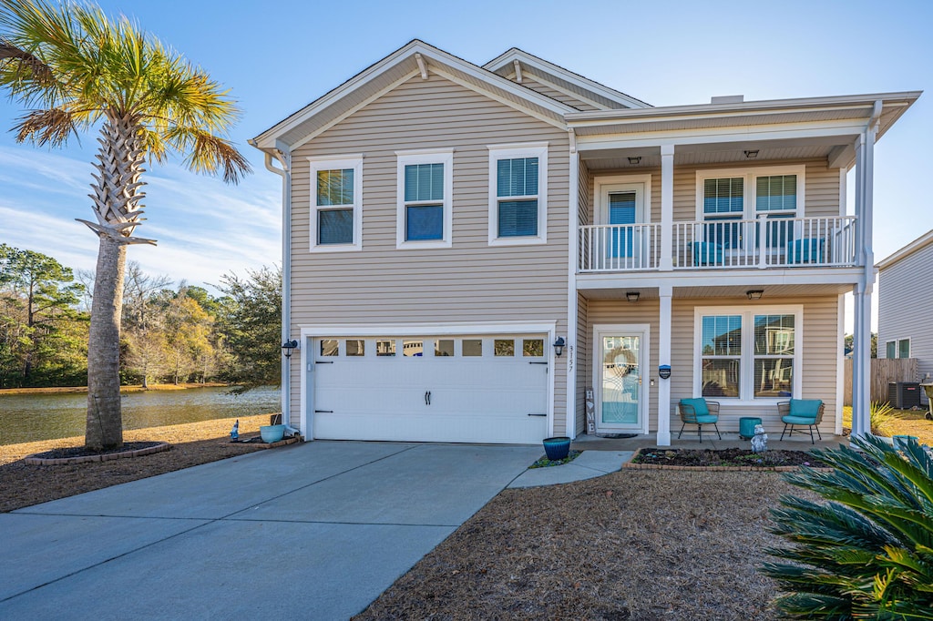 view of front of property featuring a garage, a balcony, and covered porch