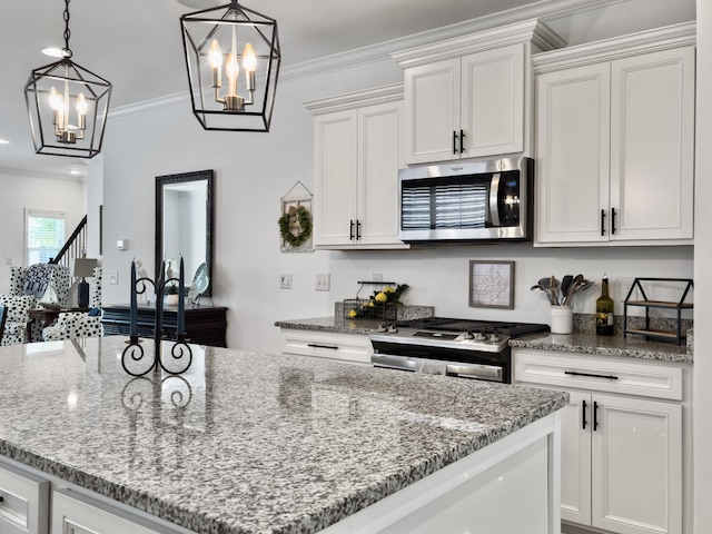 kitchen with light stone counters, an inviting chandelier, white cabinetry, and stainless steel appliances