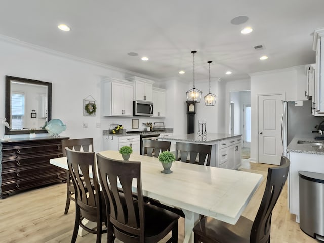 dining space featuring a wealth of natural light, visible vents, and ornamental molding