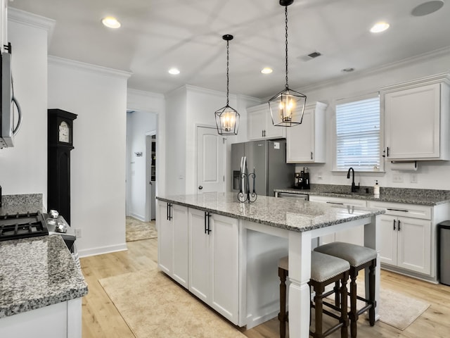 kitchen featuring stainless steel fridge with ice dispenser, a sink, ornamental molding, and visible vents