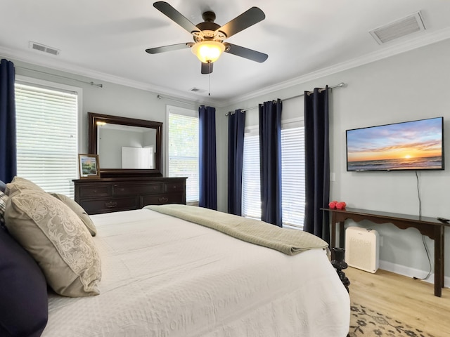 bedroom with crown molding, wood finished floors, and visible vents