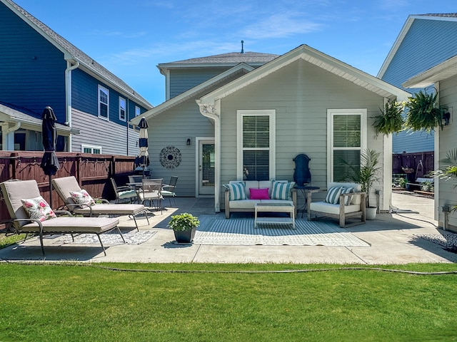 rear view of property featuring an outdoor living space, a patio, a yard, and fence