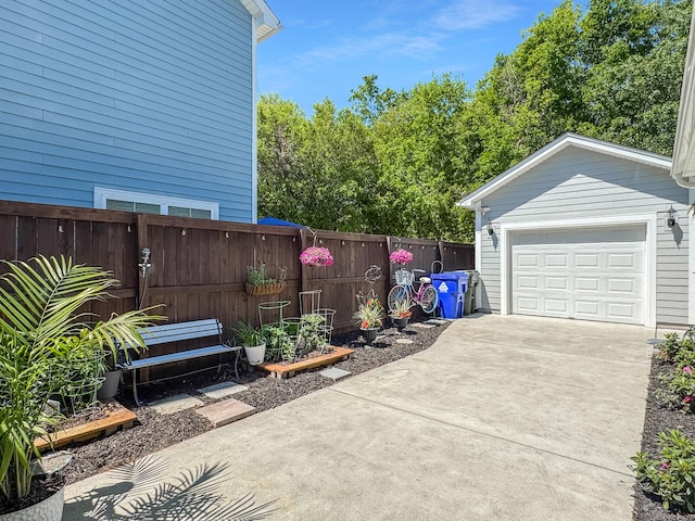view of patio / terrace with driveway, an outdoor structure, and fence
