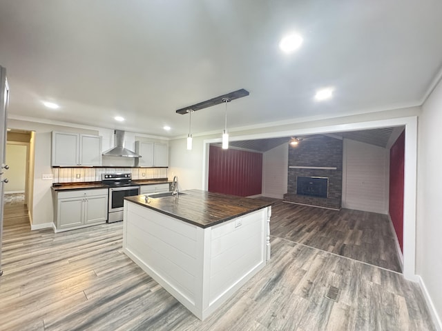 449 Estates Dr, Walterboro, SC 29488 - kitchen with stainless steel range with electric stovetop, wall chimney range hood, dark countertops, light wood-type flooring, and recessed lighting