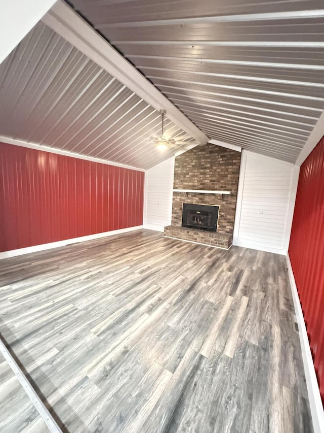 449 Estates Dr, Walterboro, SC 29488 - unfurnished living room with a brick fireplace, vaulted ceiling, wood finished floors, wooden walls, and ceiling fan