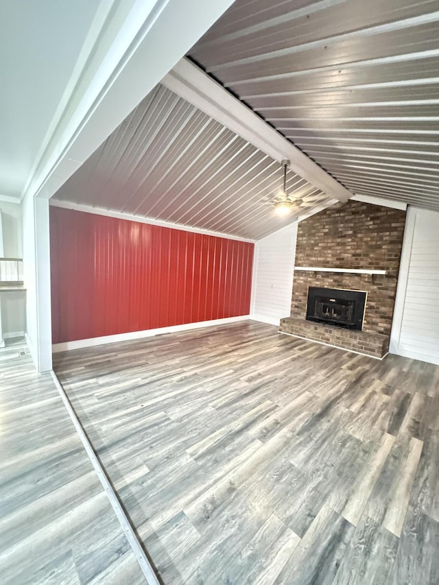 449 Estates Dr, Walterboro, SC 29488 - unfurnished living room featuring a fireplace, wood finished floors, wood walls, lofted ceiling, and ceiling fan