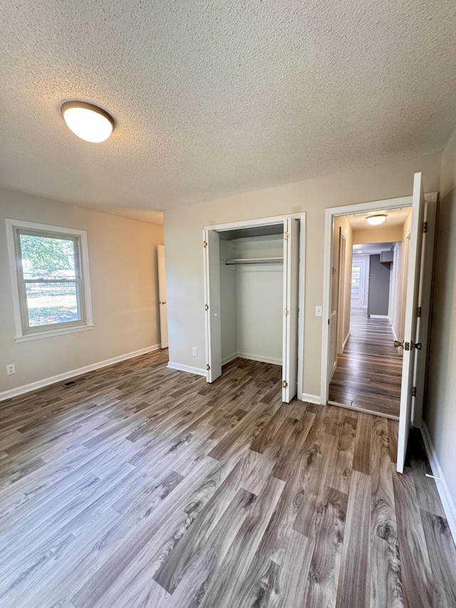 449 Estates Dr, Walterboro, SC 29488 - unfurnished bedroom featuring a textured ceiling, wood finished floors, and a closet