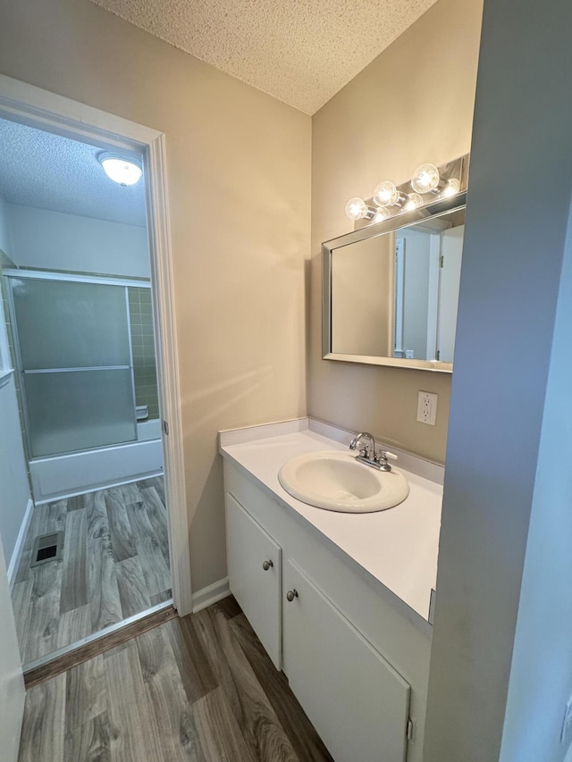 449 Estates Dr, Walterboro, SC 29488 - bathroom with a textured ceiling, vanity, wood finished floors, and combined bath / shower with glass door