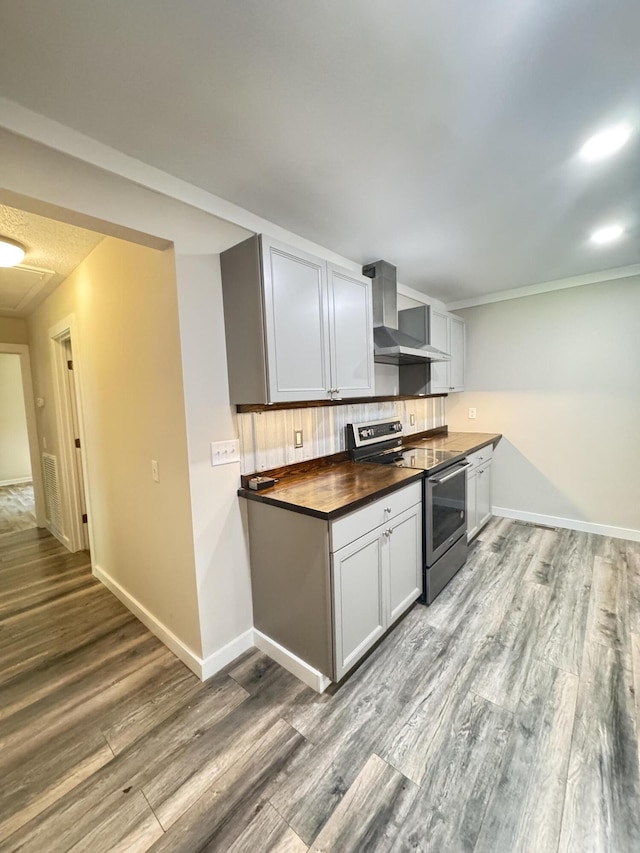 449 Estates Dr, Walterboro, SC 29488 - kitchen with stainless steel range with electric stovetop, wall chimney exhaust hood, wood finished floors, and decorative backsplash