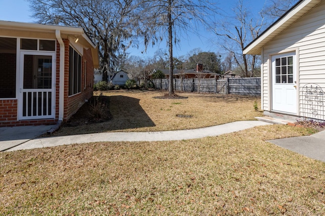 view of yard with a sunroom and fence