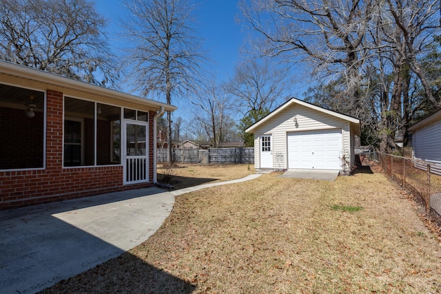 view of yard featuring a fenced backyard, an outdoor structure, driveway, and a sunroom