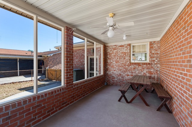 unfurnished sunroom with ceiling fan