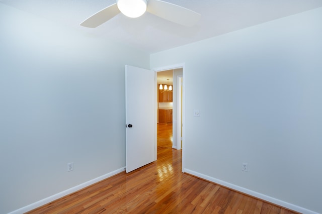 empty room with light wood-type flooring, baseboards, and a ceiling fan