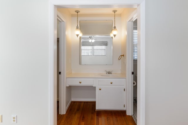 bathroom featuring vanity, wood finished floors, and baseboards