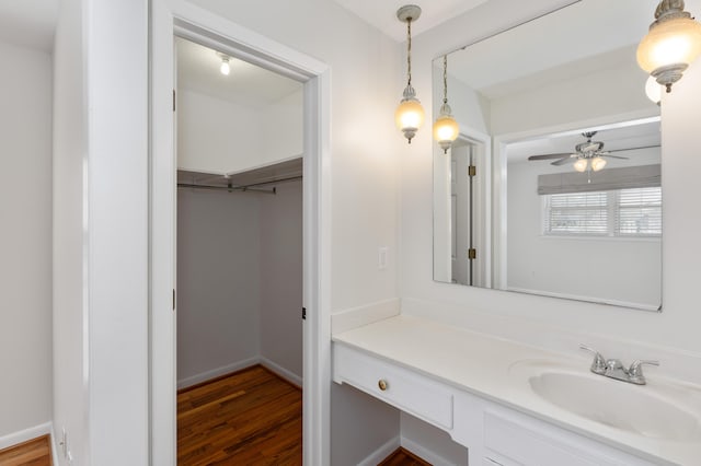 bathroom featuring baseboards, vanity, a ceiling fan, and wood finished floors