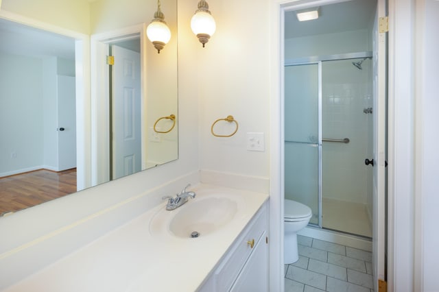 bathroom featuring vanity, toilet, and a shower stall