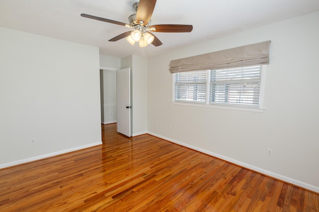 unfurnished room featuring wood finished floors, baseboards, and ceiling fan