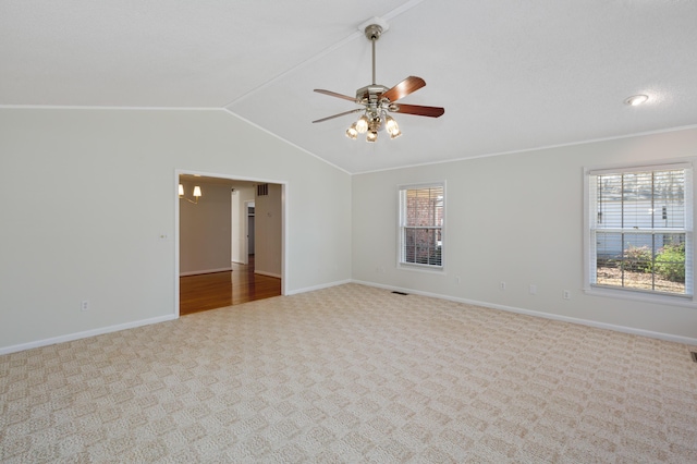 carpeted empty room with plenty of natural light, baseboards, ceiling fan, and vaulted ceiling