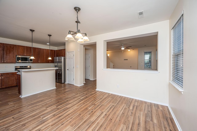 kitchen with light countertops, light wood-style flooring, baseboards, and stainless steel appliances