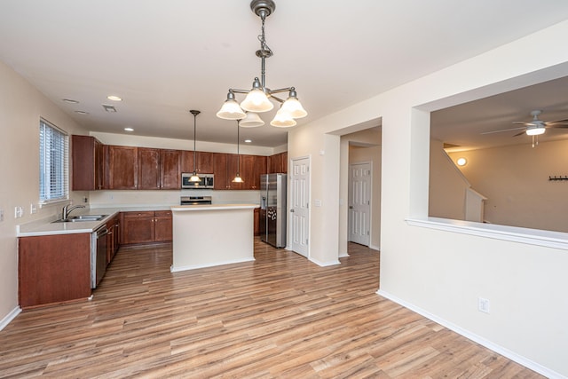 kitchen with light countertops, light wood finished floors, appliances with stainless steel finishes, and a sink