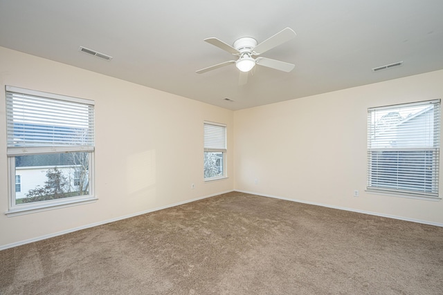 spare room featuring visible vents, baseboards, carpet, and ceiling fan