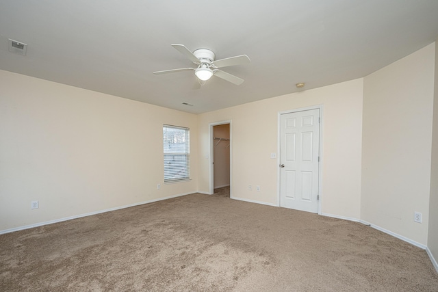 carpeted empty room featuring visible vents, baseboards, and a ceiling fan