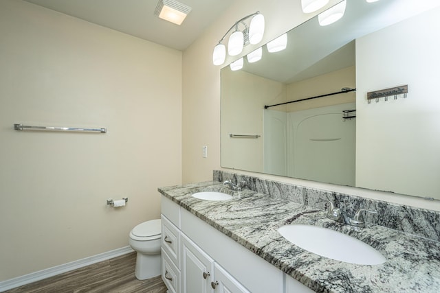 full bathroom with wood finished floors, toilet, baseboards, and a sink